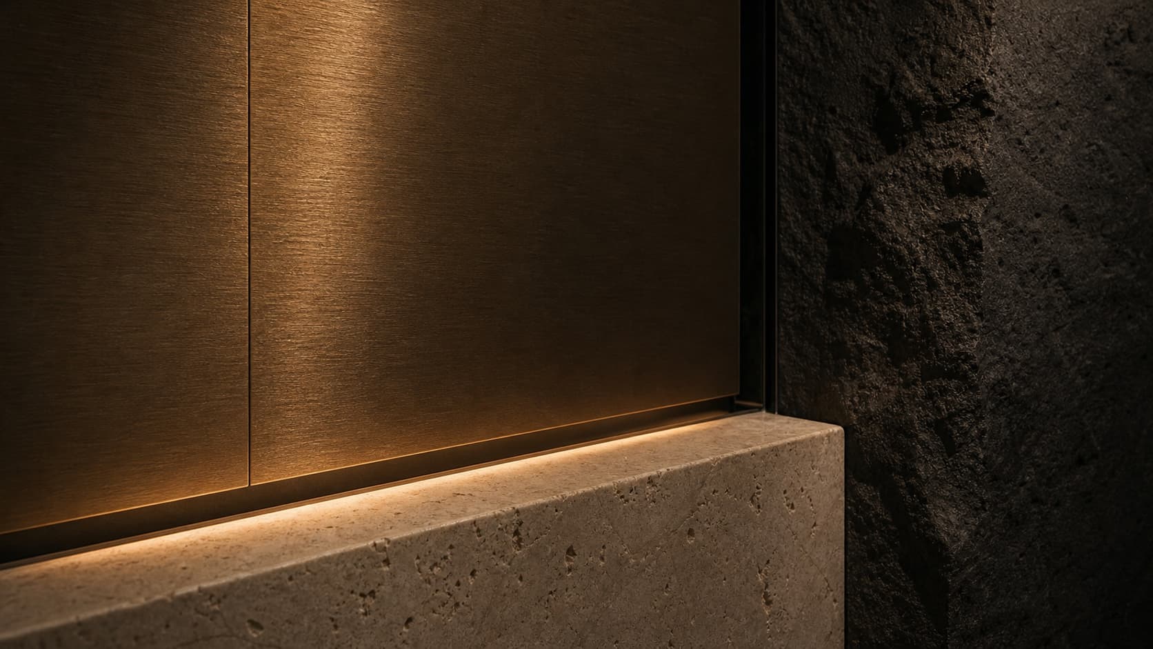 Bronze, travertine, and black stone meeting along a line of light